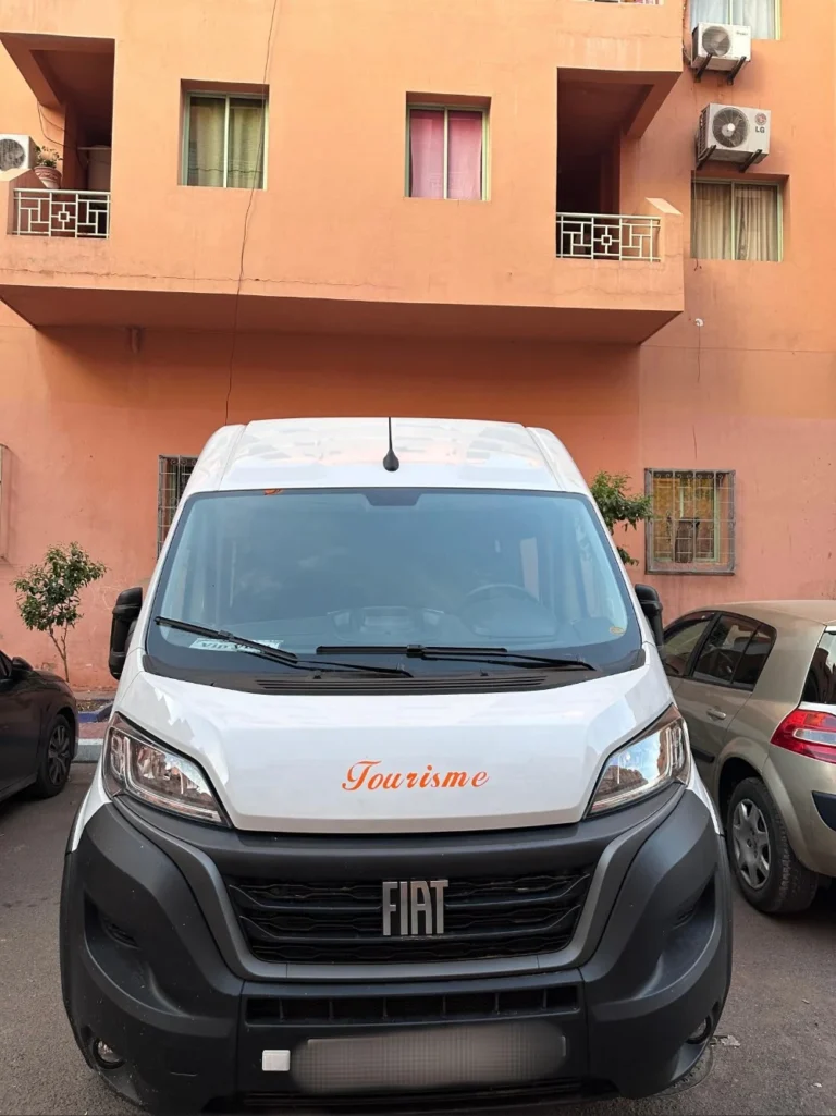 Front view of a white Fiat tourism van parked in a Marrakech residential street