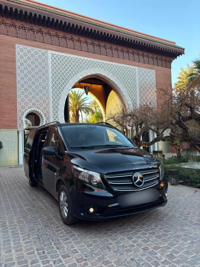 Black Mercedes Vito van parked in front of an ornate Moroccan arched entrance with carved plasterwork